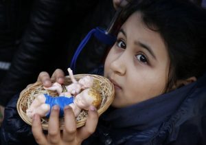Girl holds baby Jesus figurines for pope to bless during Angelus at Vatican