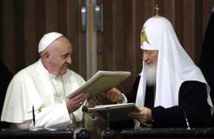 Pope Francis (L) and the head of the Russian Orthodox Church, Patriarch Kirill exchange documents during a historic meeting in Havana on February 12, 2016. Pope Francis and Russian Orthodox Patriarch Kirill kissed each other and sat down together Friday at Havana airport for the first meeting between their two branches of the church in nearly a thousand years. AFP PHOTO / POOL - Gregorio Borgia / AFP / POOL / GREGORIO BORGIA