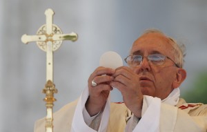 Pope Francis elevates the Eucharist as he celebrates Mass on the feast of Corpus Christi outside the Basilica of St. John Lateran in Rome June 19. (CNS photo/Paul Haring) (June 19, 2014) See POPE-PROCESSION and POPE-CORPUSCHRISTI June 19, 2014
