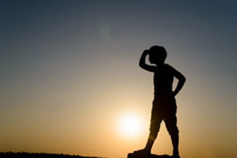 silhouette-young-boy-looking-distance-searching-hand-shielding-eyes-backlit-late-day-sun-copy-space-55435806