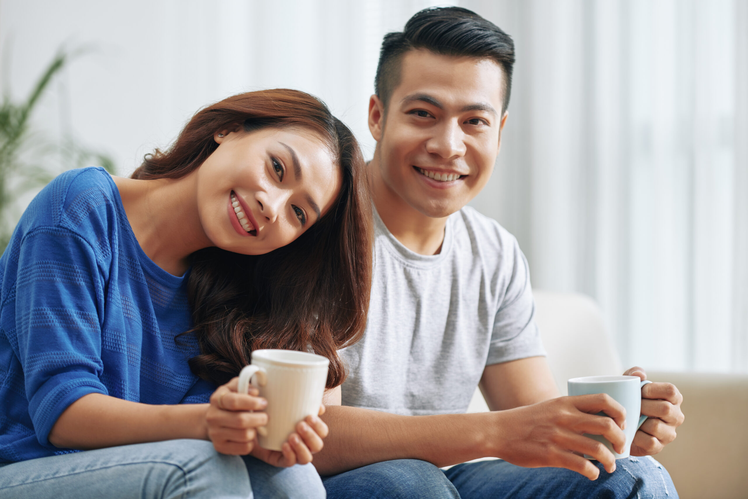 https://dongten.net/wp-content/uploads/2024/03/happy-asian-couple-sitting-couch-home-with-tea-mugs-smiling-scaled.jpg